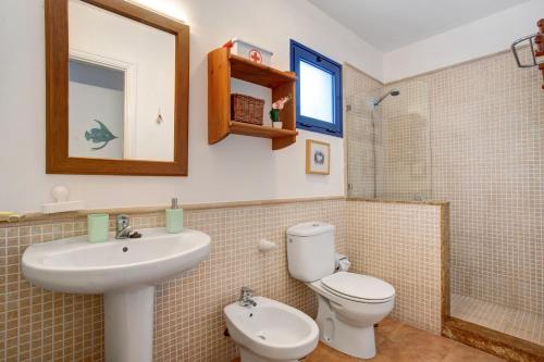 a bathroom with a sink and a toilet and a mirror at Casa Vivo in Famara