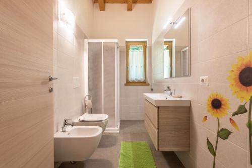 a bathroom with a sink and a toilet and a mirror at Nonno Bigi Girasole in Tremosine Sul Garda