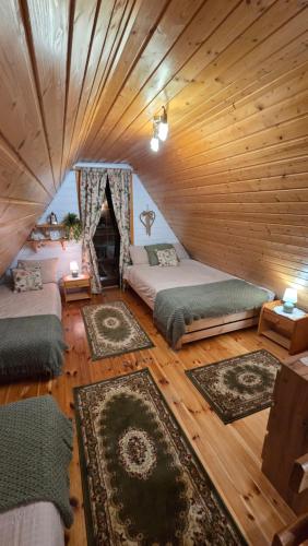 a room with two beds and a fireplace in a cabin at Chatki Małgorzatki in Bystre