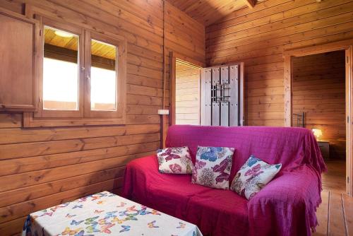 a purple couch in a room with wooden walls at Casa Juana Madera in Zahora