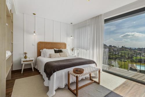 a bedroom with a bed and a large window at Casa Do Mordomo in Arcos de Valdevez