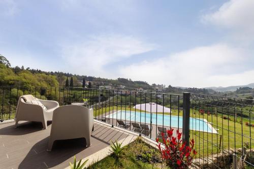 a balcony with chairs and a view of a pool at Casa Do Mordomo in Arcos de Valdevez