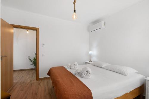 a bedroom with a white bed with towels on it at Quinta Alegre Tavira T1 in Luz de Tavira