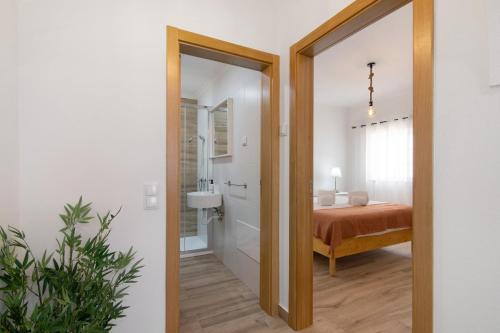 a bedroom with a bed and a bathroom with a mirror at Quinta Alegre Tavira T1 in Luz de Tavira