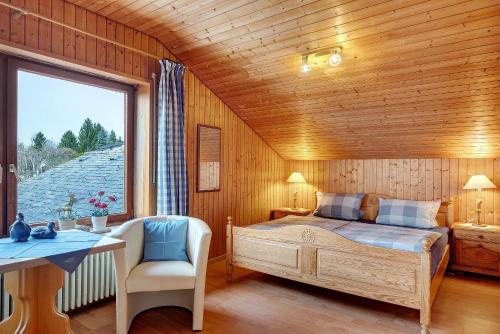 a bedroom with a bed and a desk and a window at Haus Höhensonne in Höchenschwand