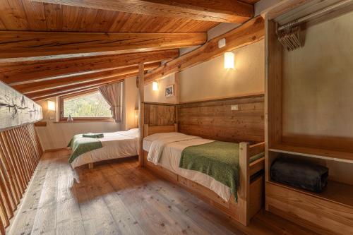 a log cabin bedroom with two beds and a window at Civico 1 in Marmora