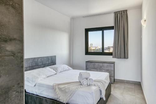 a bedroom with a bed with white sheets and a window at Giuliano Superior 1 para 4 personas in Empuriabrava