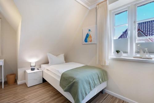 a small bedroom with a bed and a window at Ferienhaus Huus Alex in Böhl