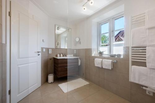 a white bathroom with a sink and a mirror at Ferienhaus Huus Alex in Böhl
