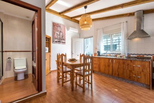 a kitchen with a table and chairs and a toilet at Apartamento a pie de playa in Benajarafe