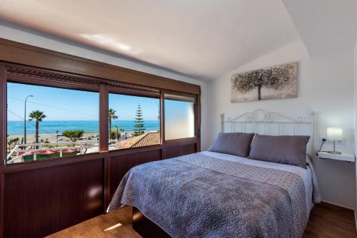 a bedroom with a bed and a view of the beach at Apartamento a pie de playa in Benajarafe