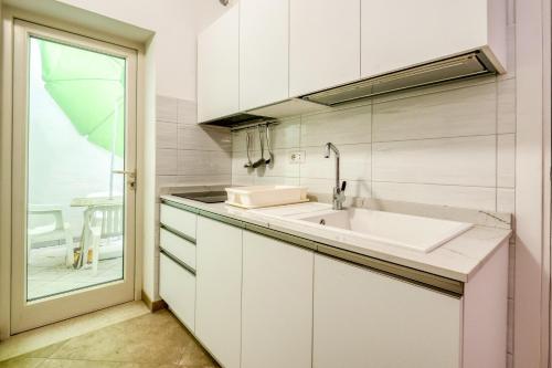 eine weiße Küche mit Spüle und Fenster in der Unterkunft Monolocale Volta in Nardò