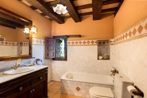 a bathroom with a tub and a toilet and a sink at La Masia in El Bruc