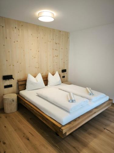 a bedroom with a large bed with white sheets and pillows at Die entspannende Eiche in San Pancrazio dʼUltimo