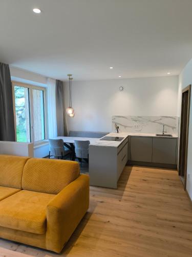 a living room with a couch and a kitchen at Die entspannende Eiche in San Pancrazio dʼUltimo