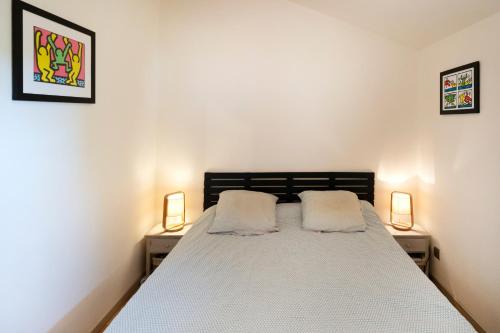 a bedroom with a bed with two lamps on both sides at Maison Chaleureuse Avec Terrasse in Capbreton