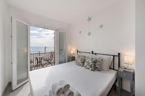 a bedroom with a large bed and a balcony at Profumo di Salsedine in Bonassola