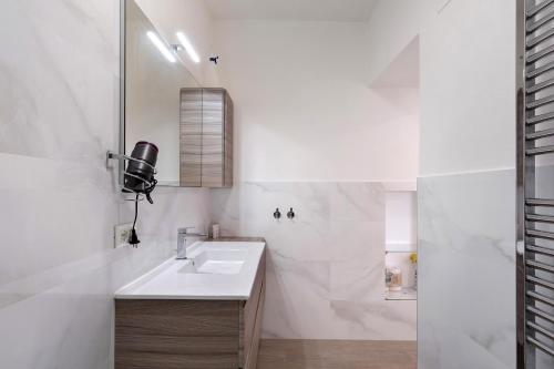 a white bathroom with a sink and a shower at Profumo di Salsedine in Bonassola