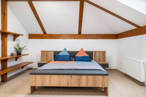 a bedroom with a bed with blue and orange pillows at Großes Ferienhaus Im Grünen - in Dummerstorf
