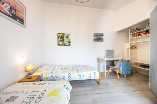 a small bedroom with a bed and a desk at Agréable Maison Sablaise in Les Sables-d'Olonne