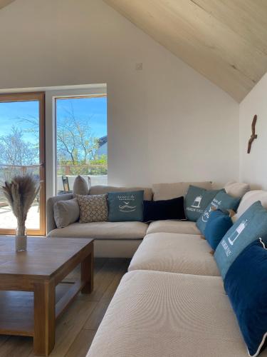 a living room with a couch and a table at Villa Grande Est idéal famille Spa in Plounéour-Trez