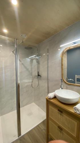 a bathroom with a shower and a sink and a mirror at Villa Grande Est idéal famille Spa in Plounéour-Trez
