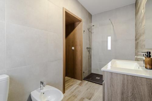 a white bathroom with a sink and a toilet at Casa Vilarinha Gerês in Bouro