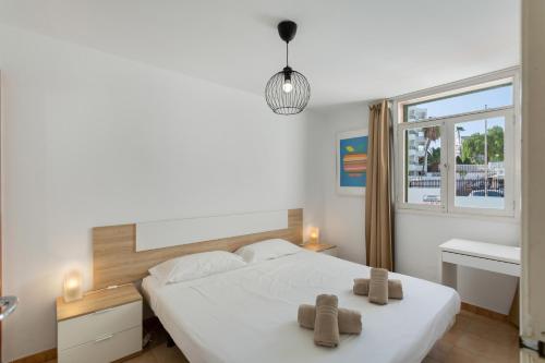 a bedroom with a bed with two towels on it at Apartamento Yumbo Centro in Maspalomas