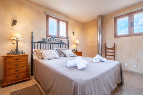a bedroom with a large bed with towels on it at Casa Brava in Santanyi
