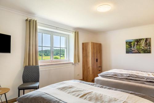 a bedroom with a bed and a window at Ferienwohnungen Mayerhofer in Arnstorf