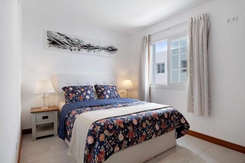 a white bedroom with a bed and a window at Villa Khaleesi in Playa Blanca