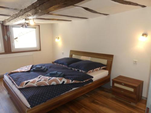 a bedroom with a bed with blue pillows and a window at Ferienhaus Villa Wolffsschlucht in Oberzent