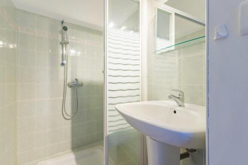 a white bathroom with a sink and a shower at L'amourié, Rdc, Gîte 4 Personnes in Sainte-Croix-de-Verdon