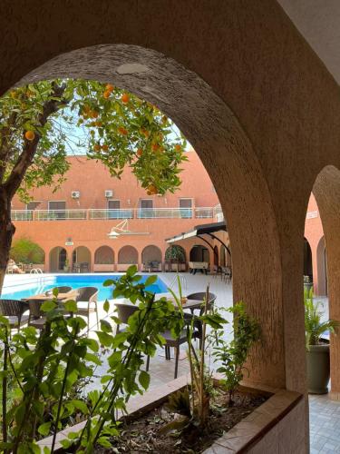 an archway leading into a courtyard with a swimming pool at Hotel Tiznit in Tiznit