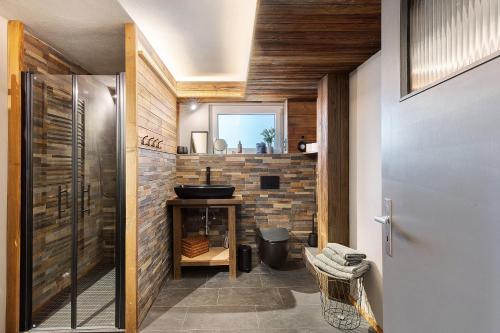 a bathroom with a sink and a brick wall at Wanderer Lodge am Breitenstein in Bissingen an der Teck