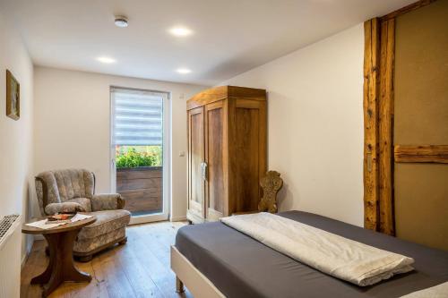 a bedroom with a bed and a chair and a window at Dalblick in Oberharmersbach
