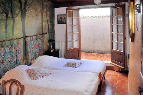 two beds in a room with a window at Gîte De Diane in Allemagne-en-Provence