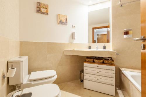a bathroom with a toilet and a sink and a mirror at Cubelles mar in Cubelles