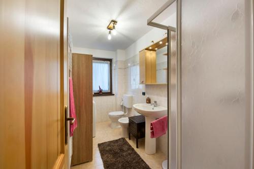 a bathroom with a white toilet and a sink at Gioiello Col de Joux in Saint Vincent