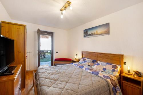 a bedroom with a bed and a flat screen tv at Gioiello Col de Joux in Saint Vincent