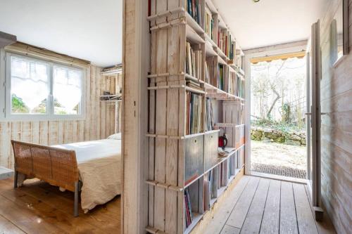 a bedroom with a book shelf filled with books at La Cabane de Bébert - Marie en Lys in Cap-Ferret