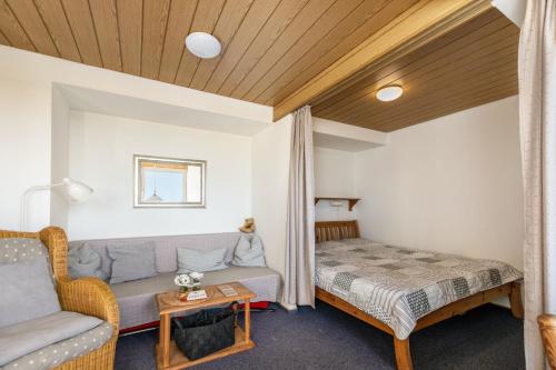 a bedroom with a couch and a bed in a room at Whg 1- Ferien auf einem Resthof in Schönhagen