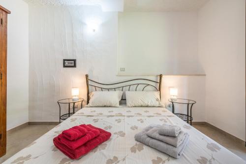 a bedroom with a bed with red towels on it at Villa Eleonora Residence App to 4 in Capoterra