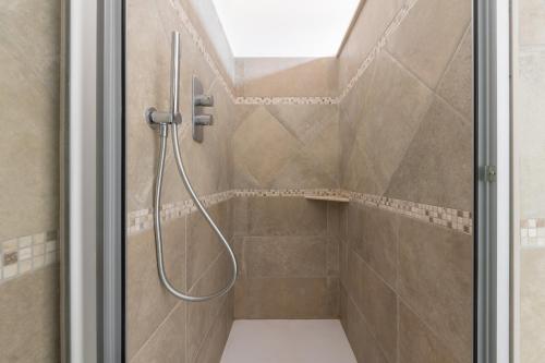 a shower with a hose in a bathroom at Villa Eleonora Residence App to 4 in Capoterra