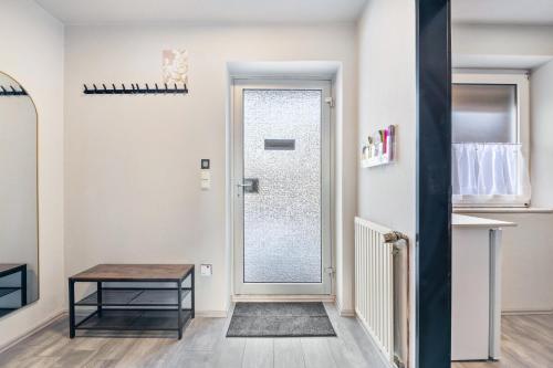 a hallway with a glass door and a table at Klein aber fein in Worpswede