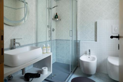 a bathroom with a shower and a sink and a toilet at Panorama Apartment 180 mq in Nago-Torbole