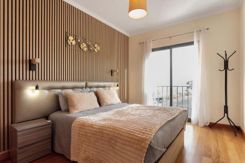 a bedroom with a bed with a striped wall at Moradia Casa Feliz in Santa Cruz