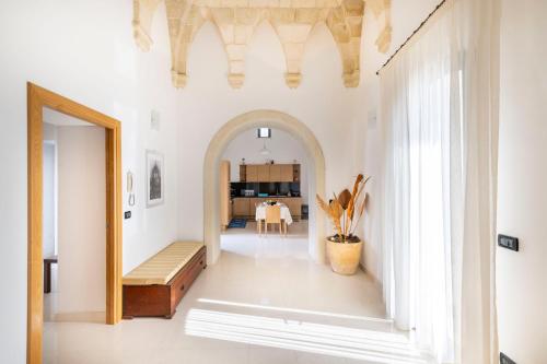 a hallway with an archway and a dining room at Casa Pizzicchia in Muro Leccese