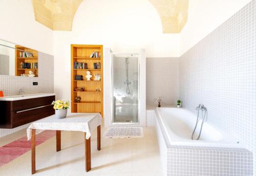 a bathroom with a tub and a sink at Casa Pizzicchia in Muro Leccese