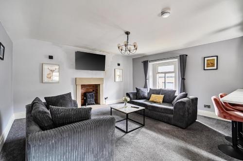 a living room with two couches and a fireplace at Cosy Apartment above Village Pub in Buxton